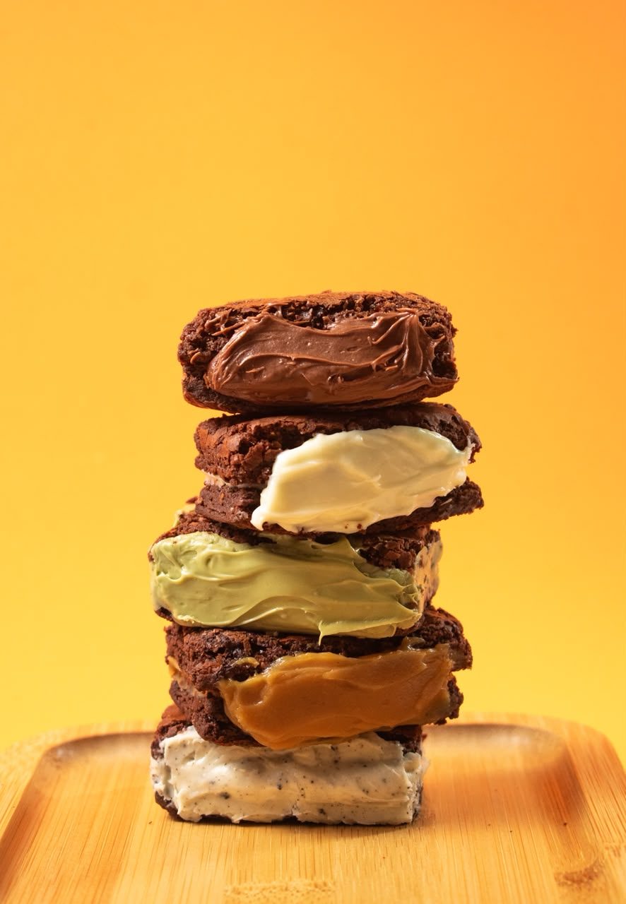 Pilha de brownies recheados de Nutella, leitinho, pistache, doce de leite e cookies and cream