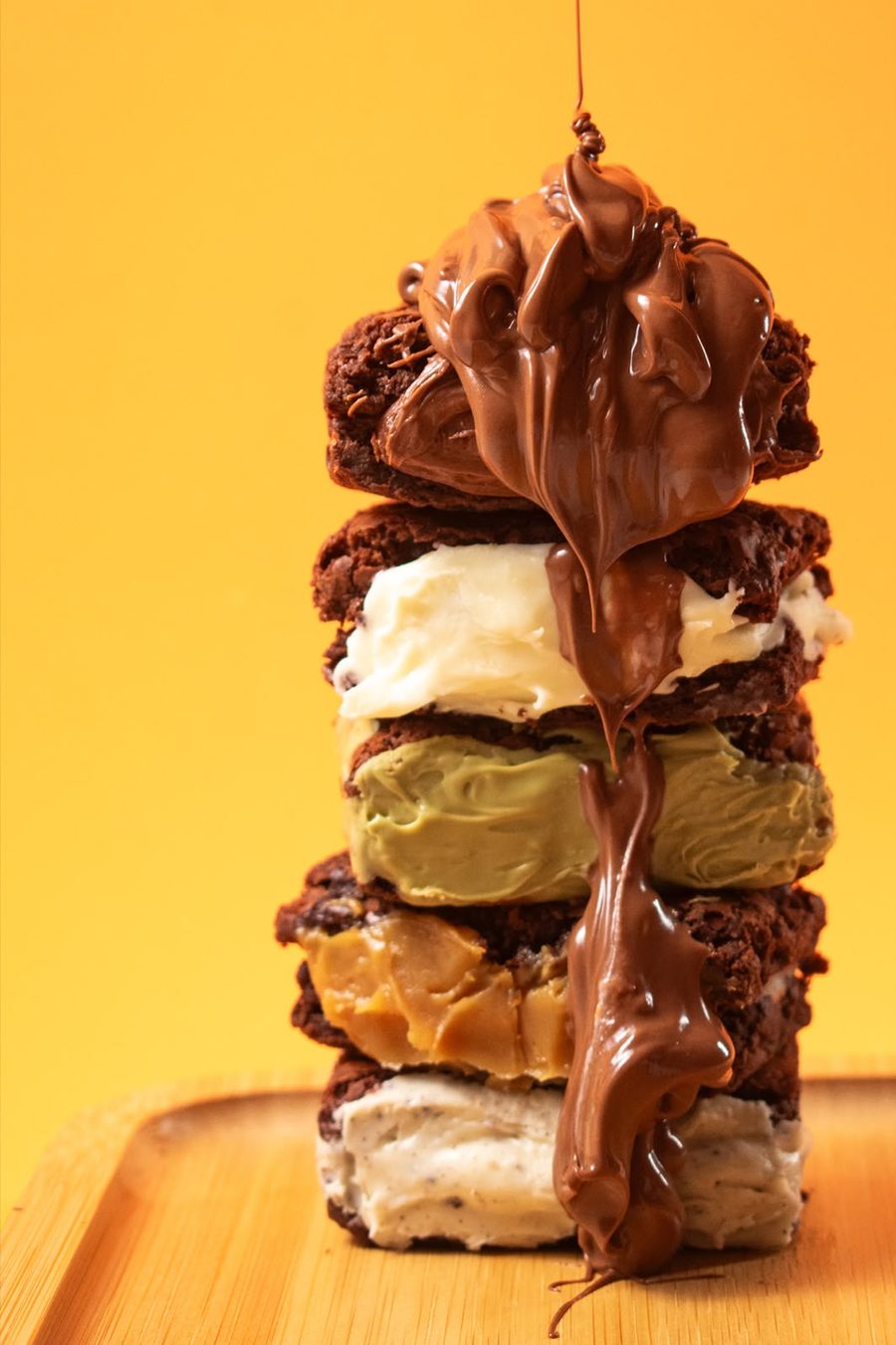 Pilha de brownies com recheios de Nutella, leitinho, pistache, doce de leite e cookies and cream